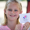 Blonde girl holding a card.
